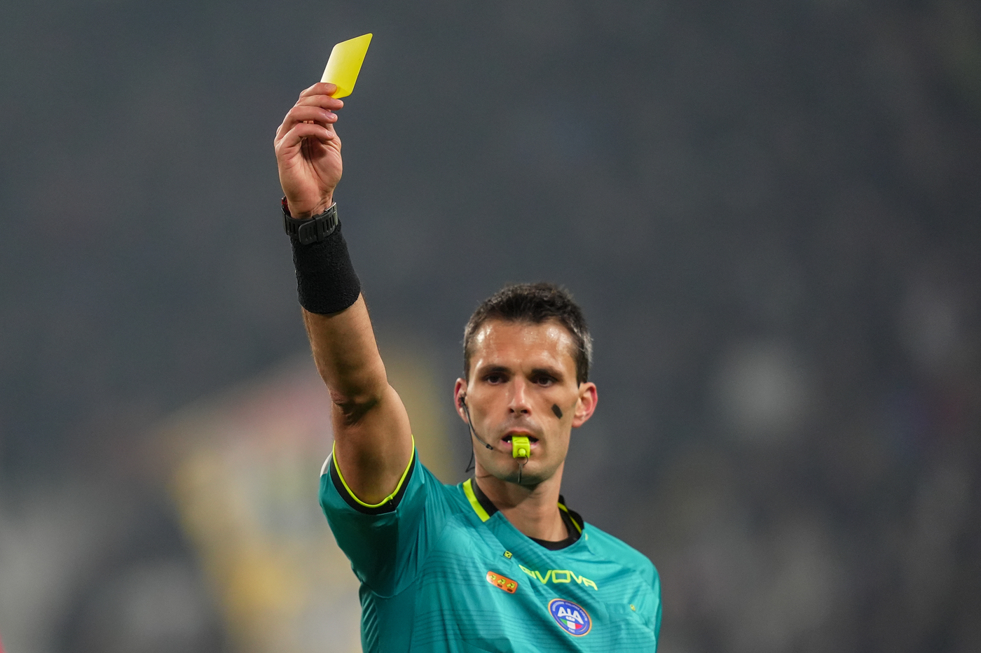 Un arbitro sventola un giallo